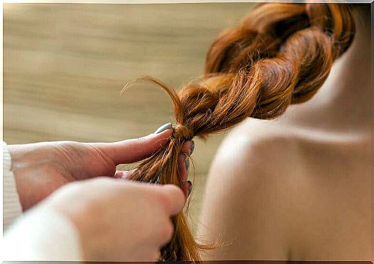 A braid is being braided for a woman.