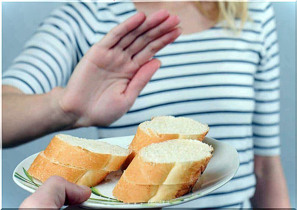 A woman refuses a plate of white bread.