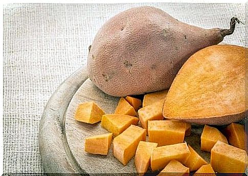 Two sweet potatoes, one of which is cut open.