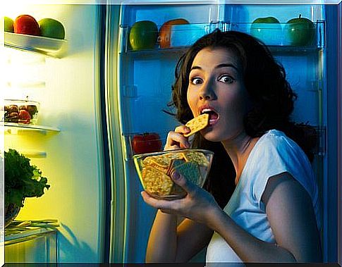 Woman in front of the refrigerator puts diet success at risk