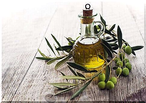 Olive oil in a glass next to olives, an essential part of the Mediterranean diet